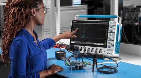 工程师使用泰克示波器和示波器探头测量被测设备上的信号