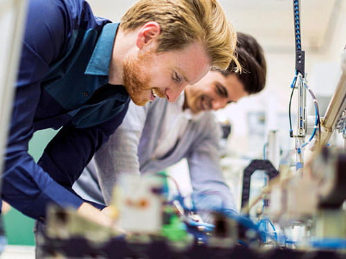 University engineering students working together using a lab power supply  for testing