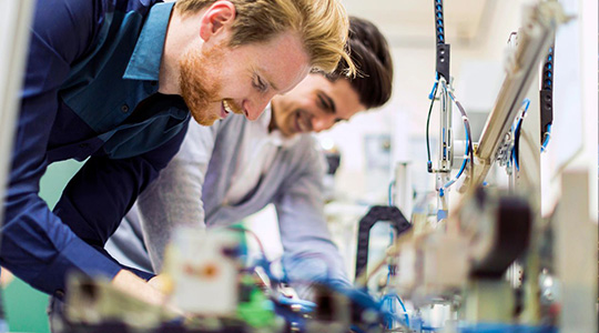 University engineering students working together using a lab power supply  for testing