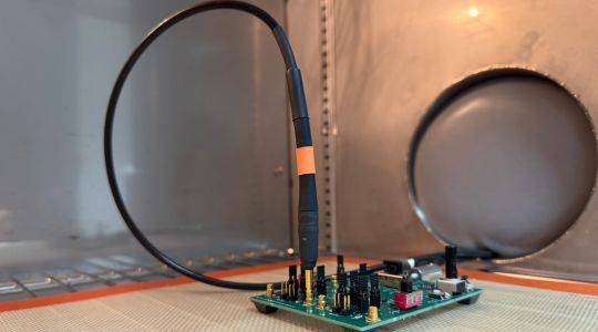 Extreme‑temperature probe tip connected to a device under test inside a temperature chamber during applied testing.