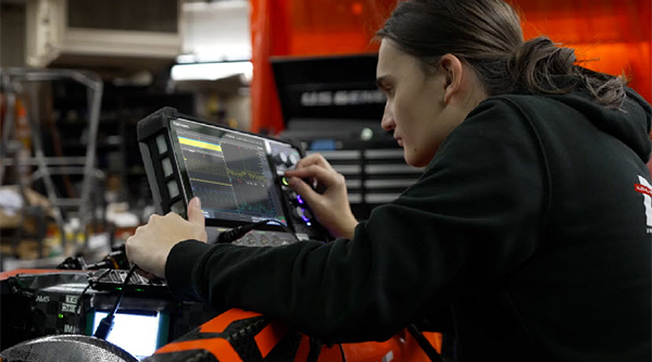Automotive engineer making measurements with an oscilloscope on an experimental EV design