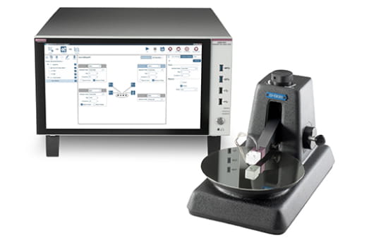 Laboratory setup featuring a probe station with a wafer and a Keithley instrument displaying a resistivity measurement.